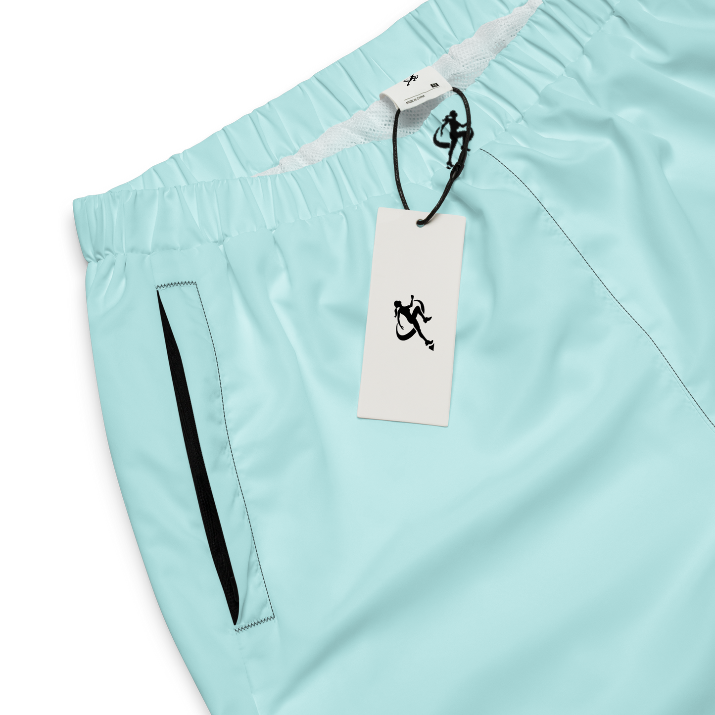 Woman wearing light blue jogger pants and a white crop top on a white background