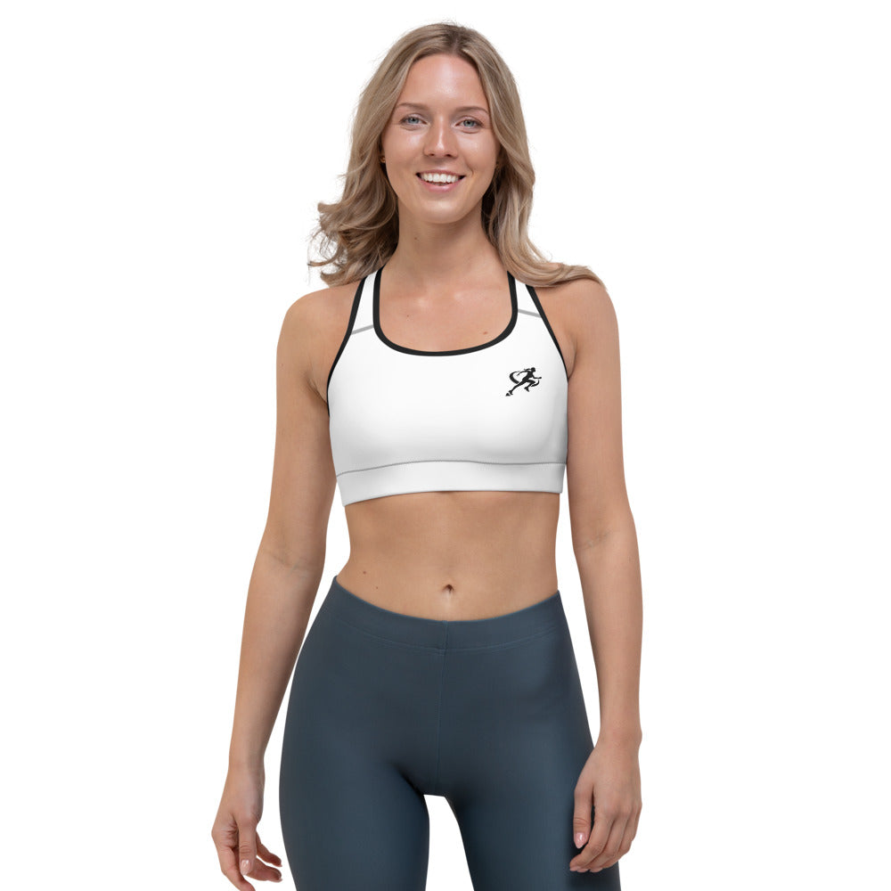 A woman wearing a white padded sports bra with a logo on the left chest area, paired with dark sports leggings.