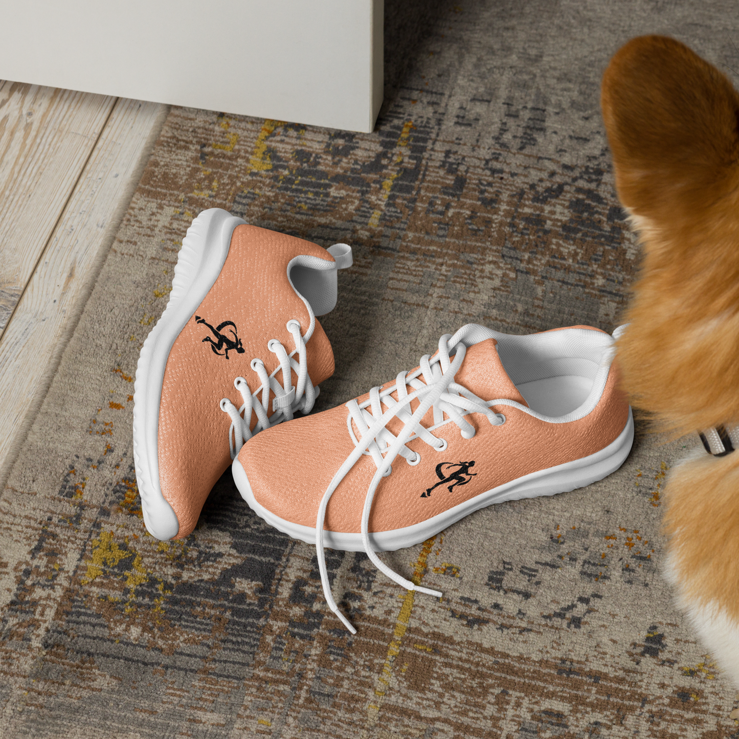 Coral running shoe with white laces on a reflective surface