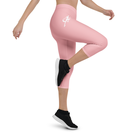Person wearing pink leggings with a logo and black athletic shoes on a white background