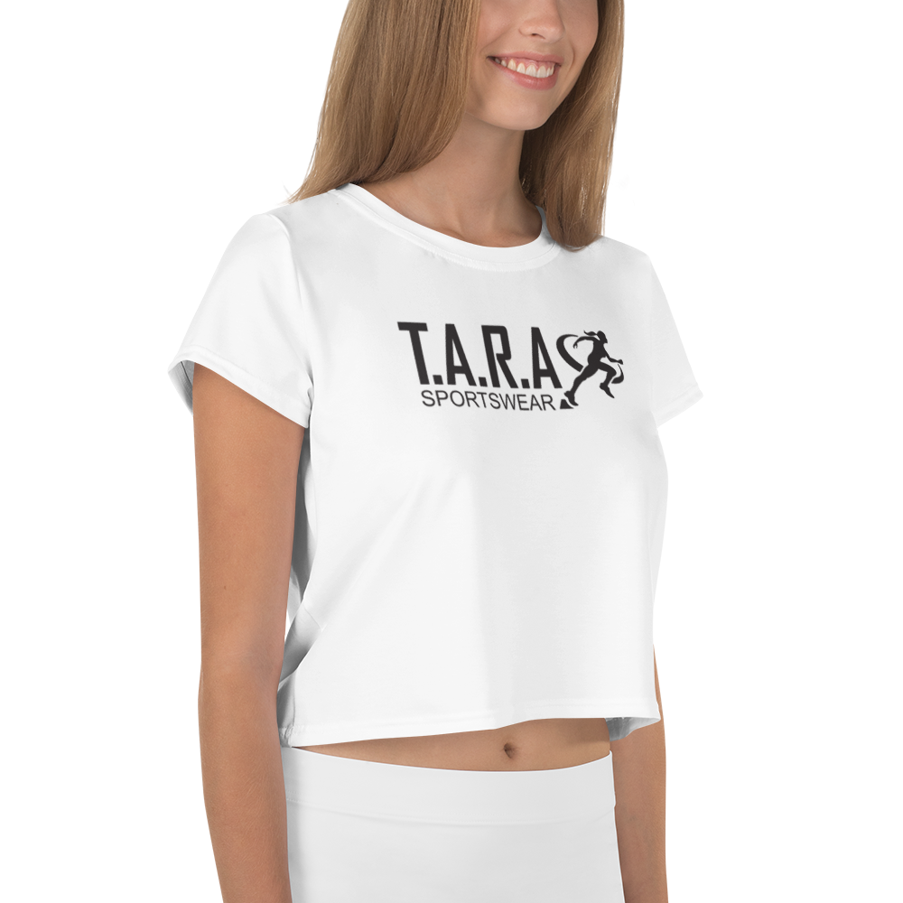 A female model wearing a white crop top with the T.A.R.A Sportswear logo on the front.