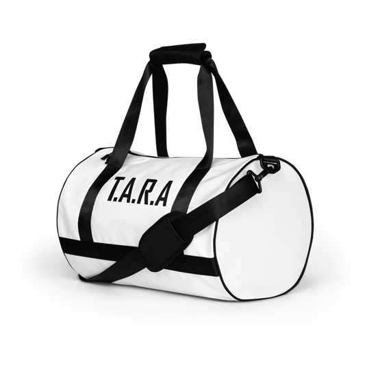 White duffel bag with black straps and 'T.A.R.A.' text on a white background
