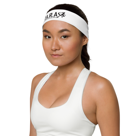 A woman wearing a white T.A.R.A Sportswear headband with a logo on the front.