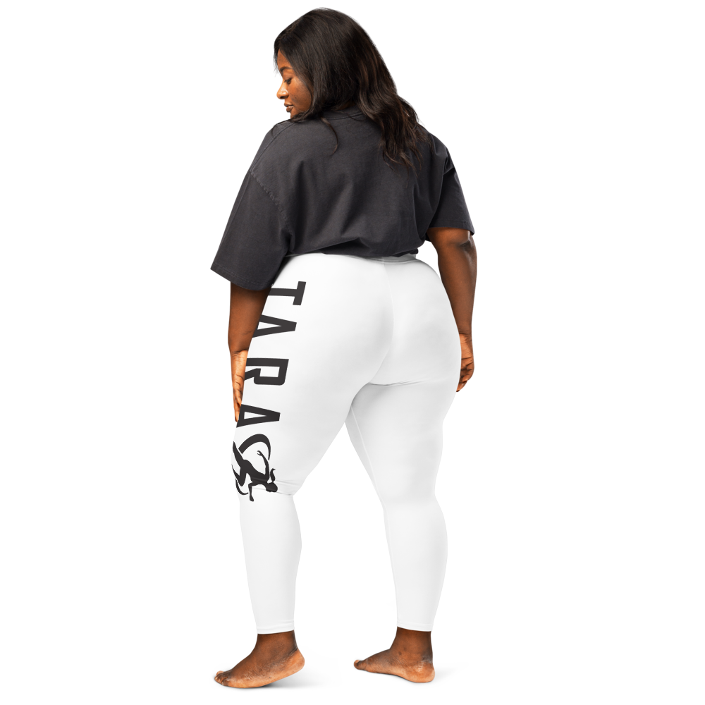 A model wearing high waisted white sportswear leggings with a logo on the side, bear footed from the side.