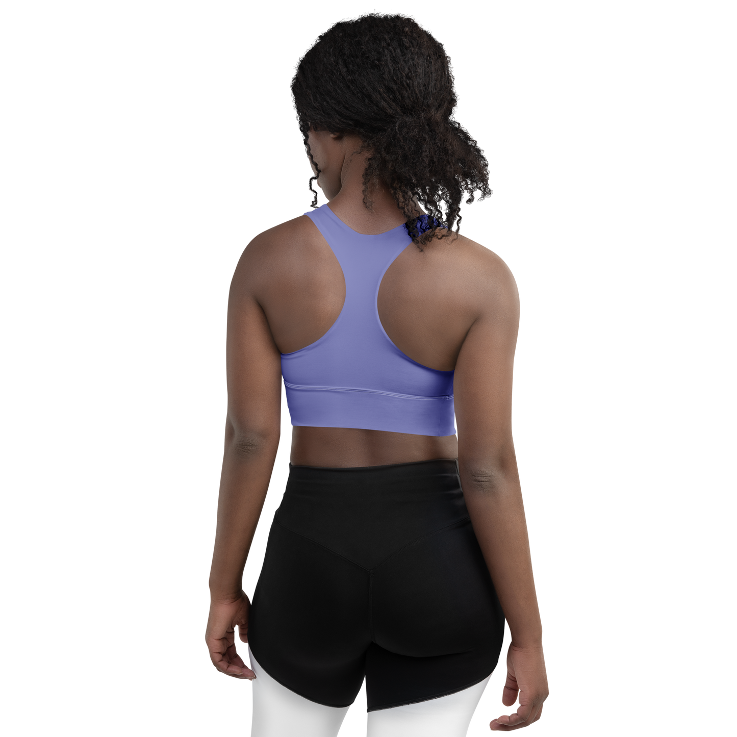 Woman wearing a purple sports bra and black leggings on a white background
