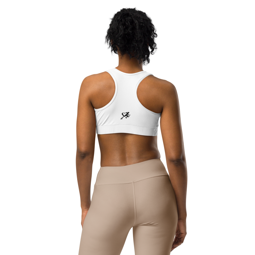 Woman wearing a white sports bra and beige leggings on a white background