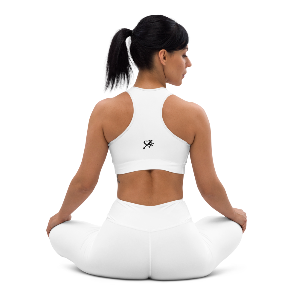 Woman wearing a white sports bra and beige leggings on a white background
