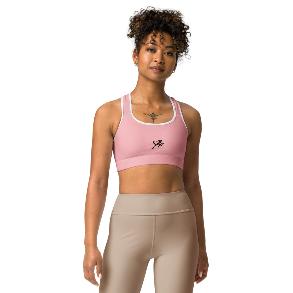 Woman wearing a pink sports bra and beige leggings on a white background