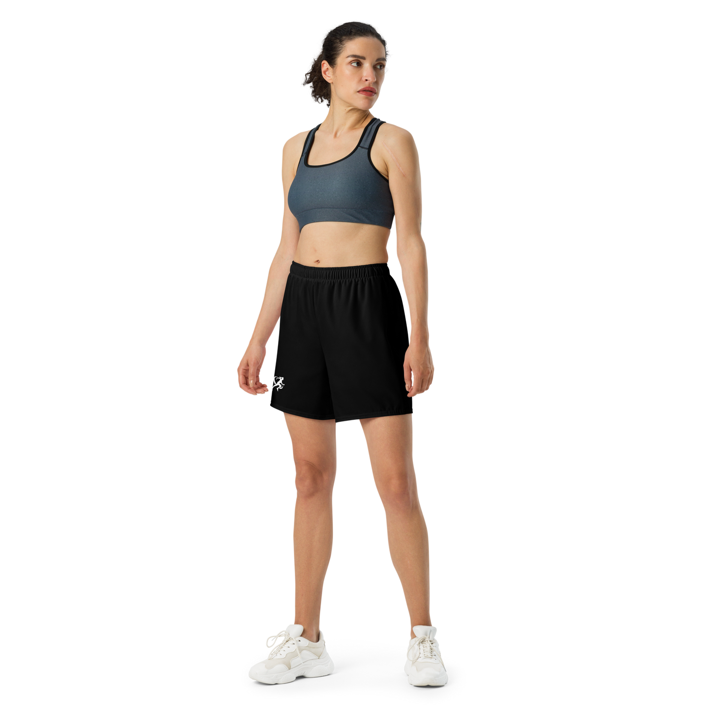 Woman wearing a sports bra and black shorts on a white background
