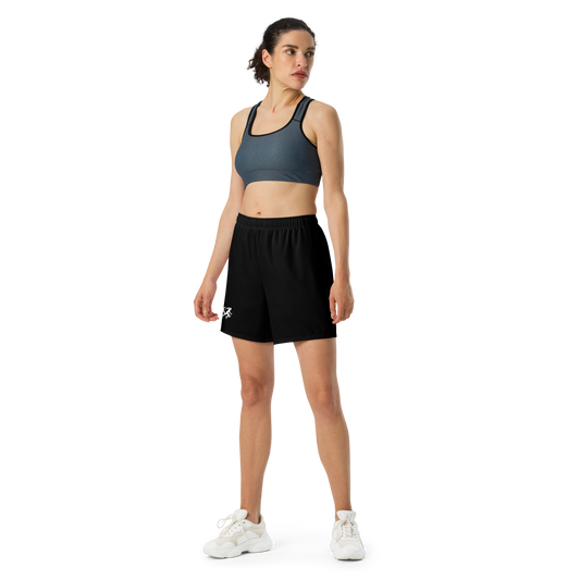 Woman wearing a sports bra and black shorts on a white background
