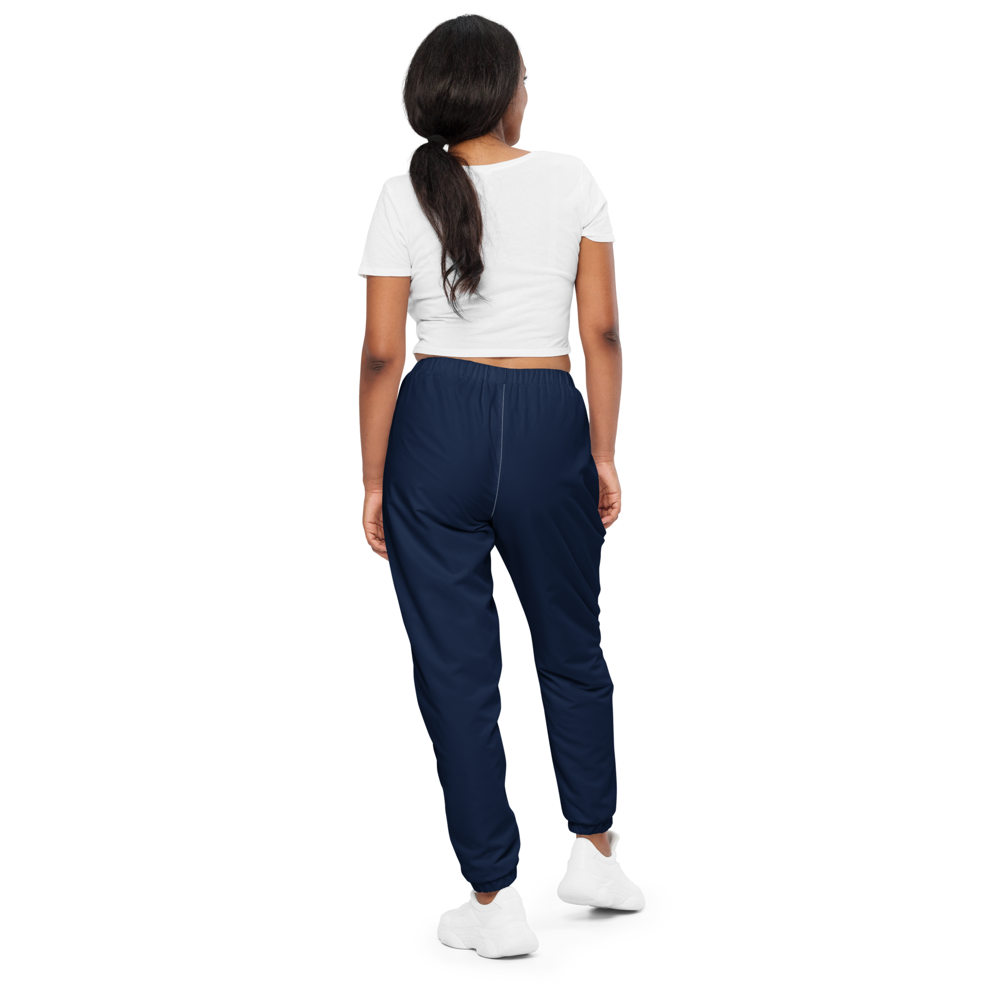Woman wearing navy jogger pants and a white crop top on a white background