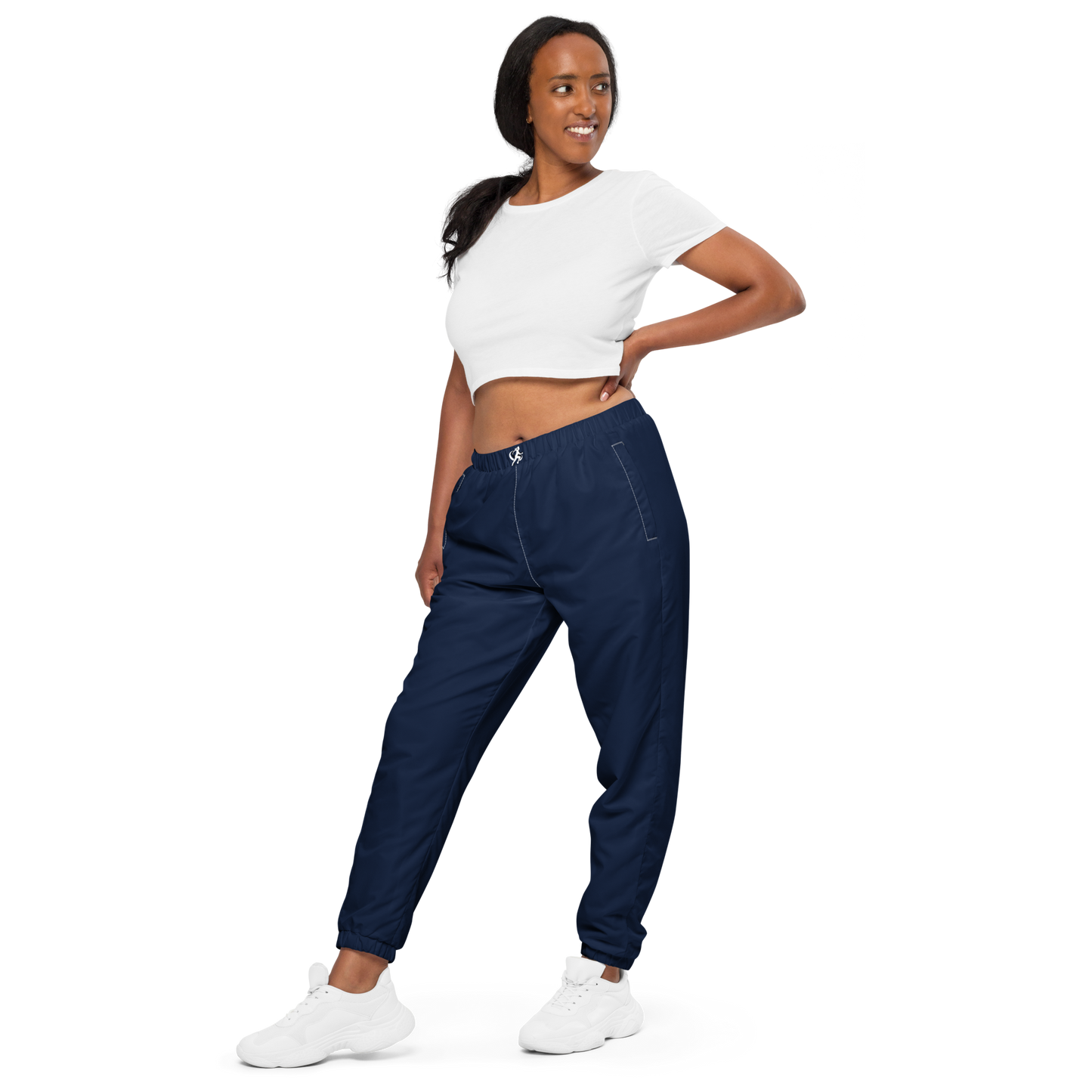Woman wearing navy jogger pants and a white crop top on a white background