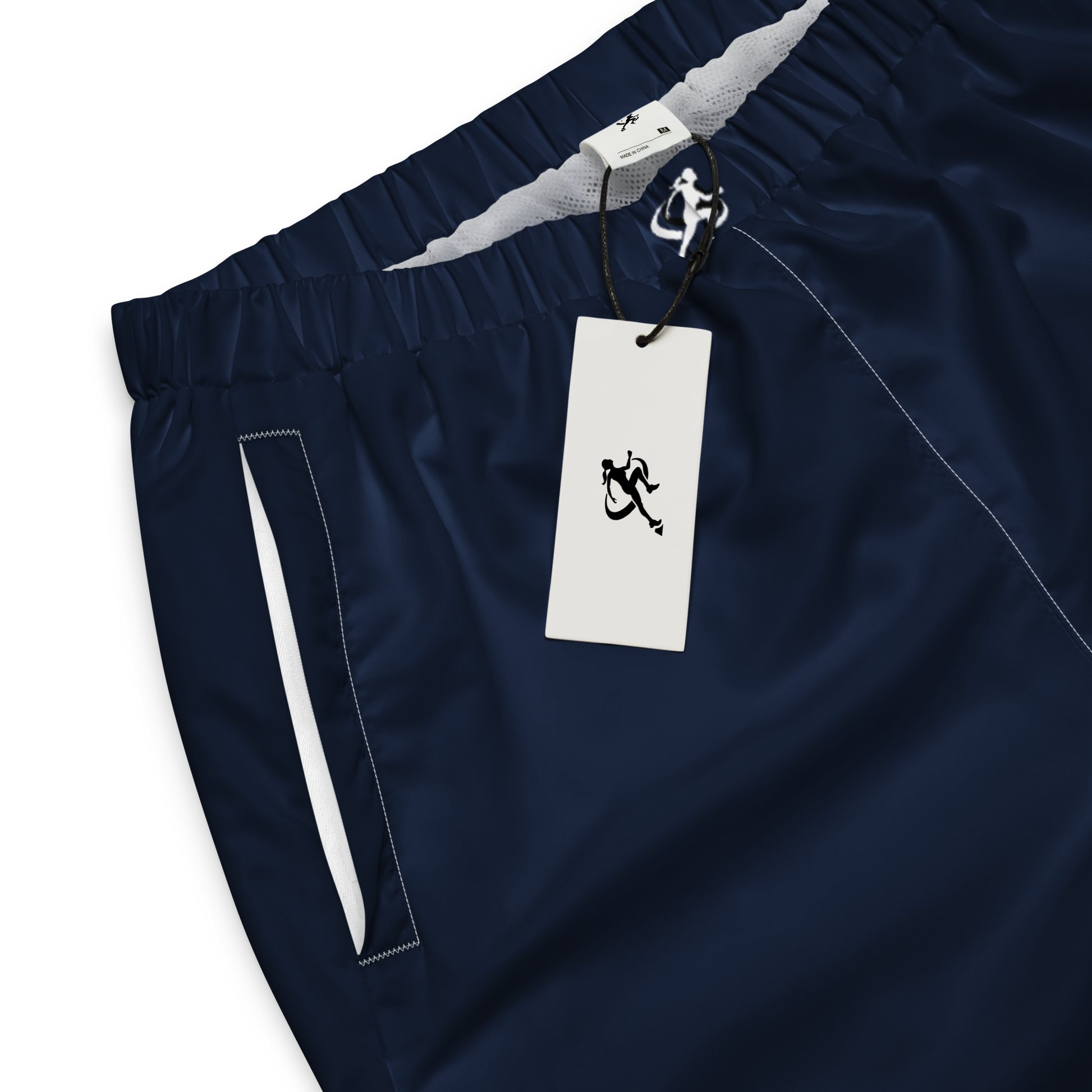 Woman wearing navy jogger pants and a white crop top on a white background