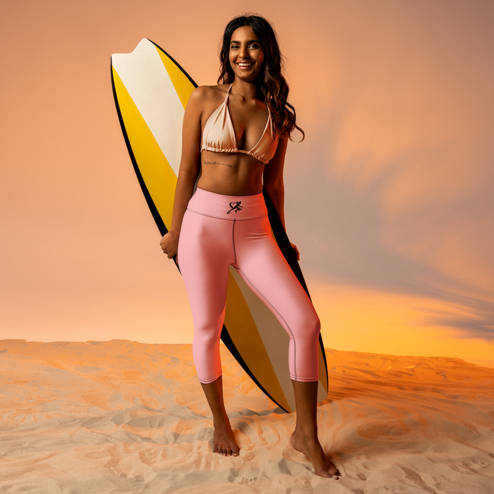 Woman holding a surfboard on a beach with a sunset background