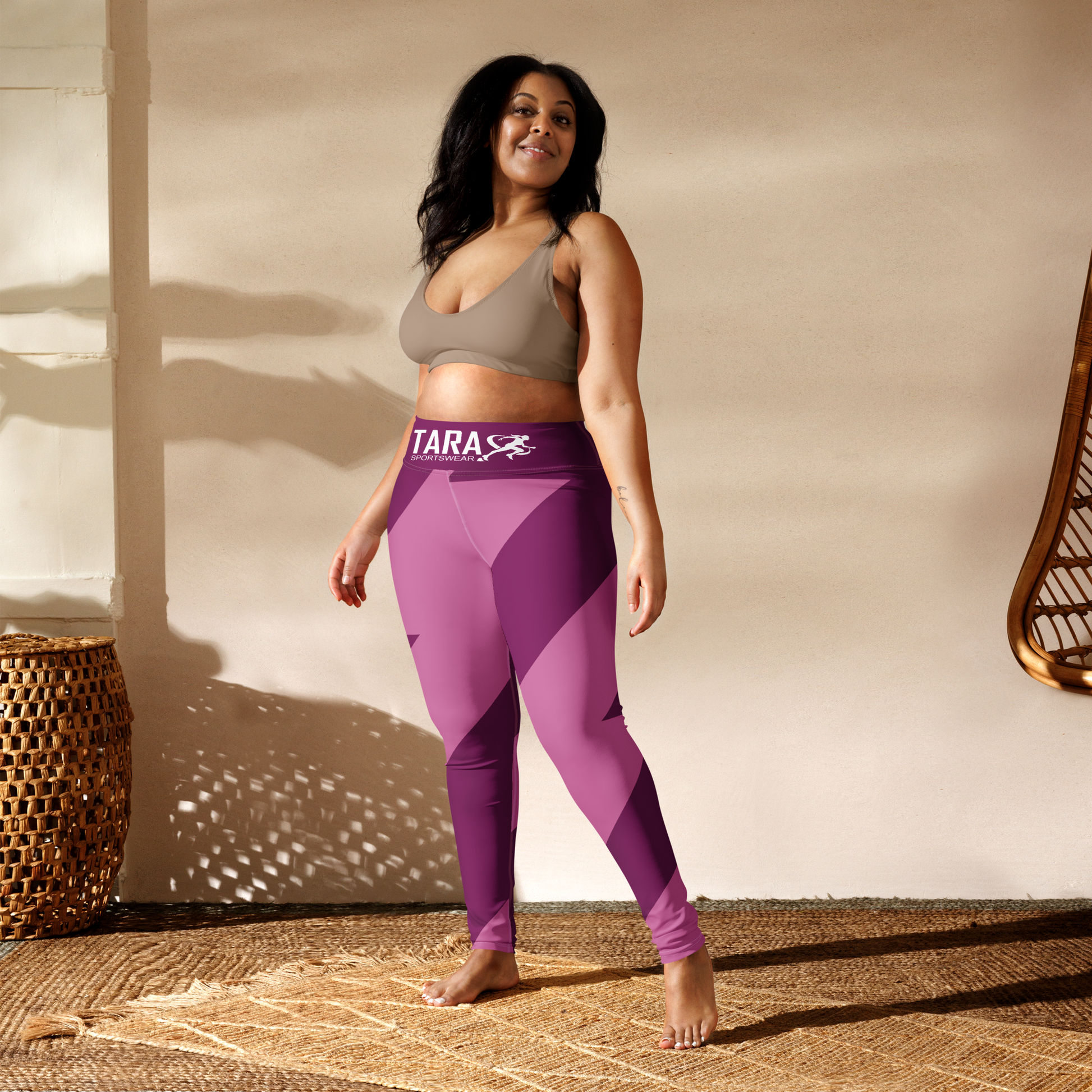 Woman wearing pink leggings with 'TARA' branding outdoors.