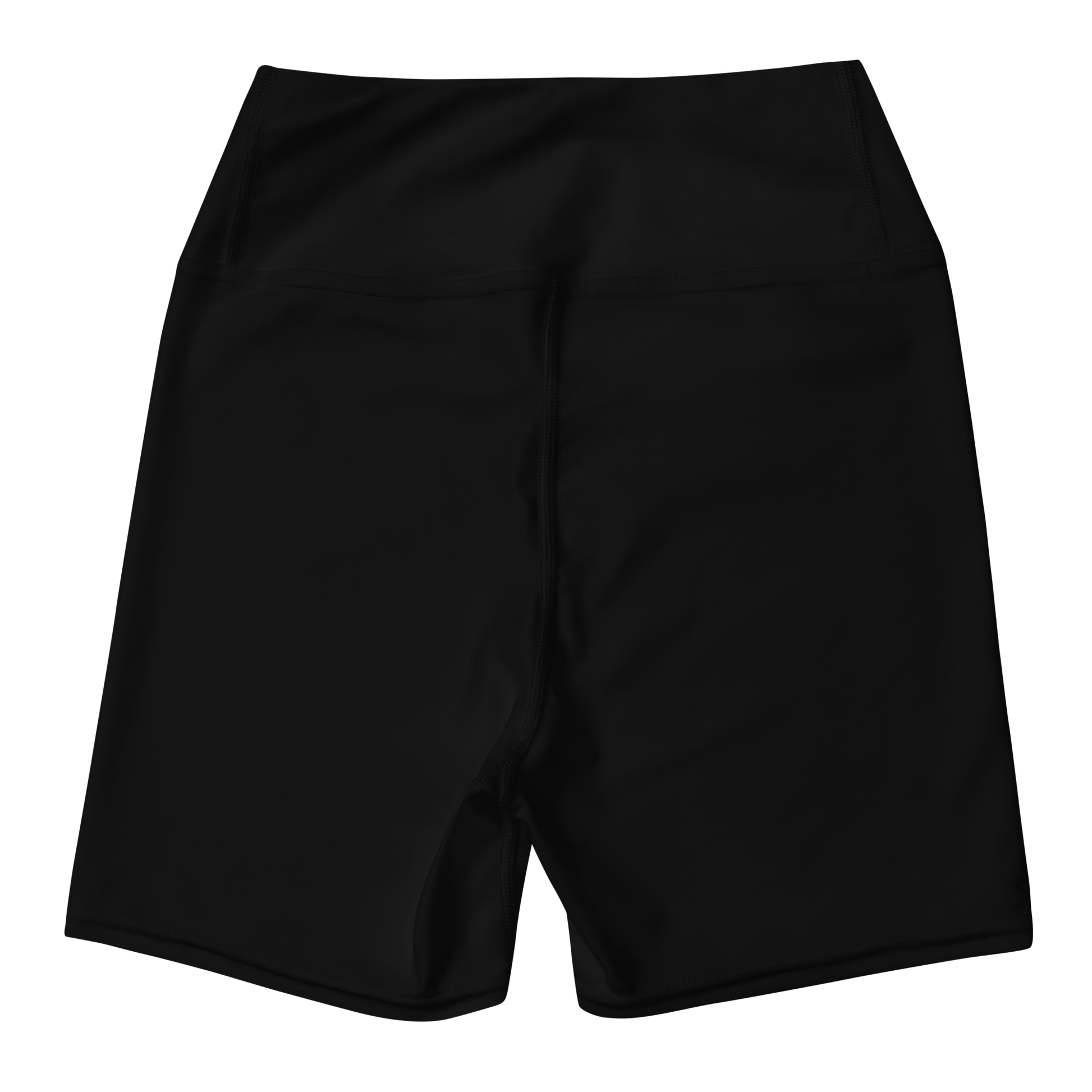 Woman in a yellow top and black shorts standing on sand with an orange sky