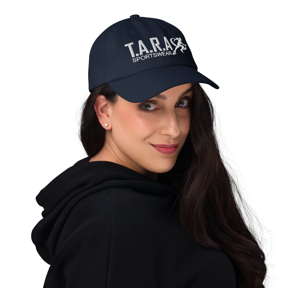 A woman wearing a navy blue cap with the logo 'T.A.R.A Sportswear' on the front.