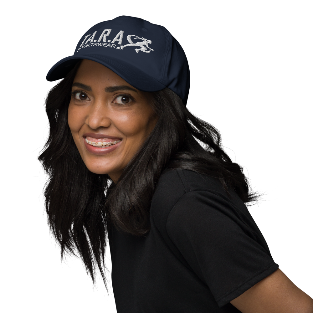 A woman wearing a navy blue cap with the logo 'T.A.R.A Sportswear' on the front.