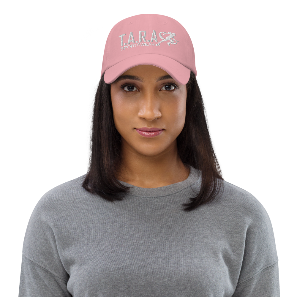 A woman wearing a pink cap with the logo 'T.A.R.A Sportswear' on the front.