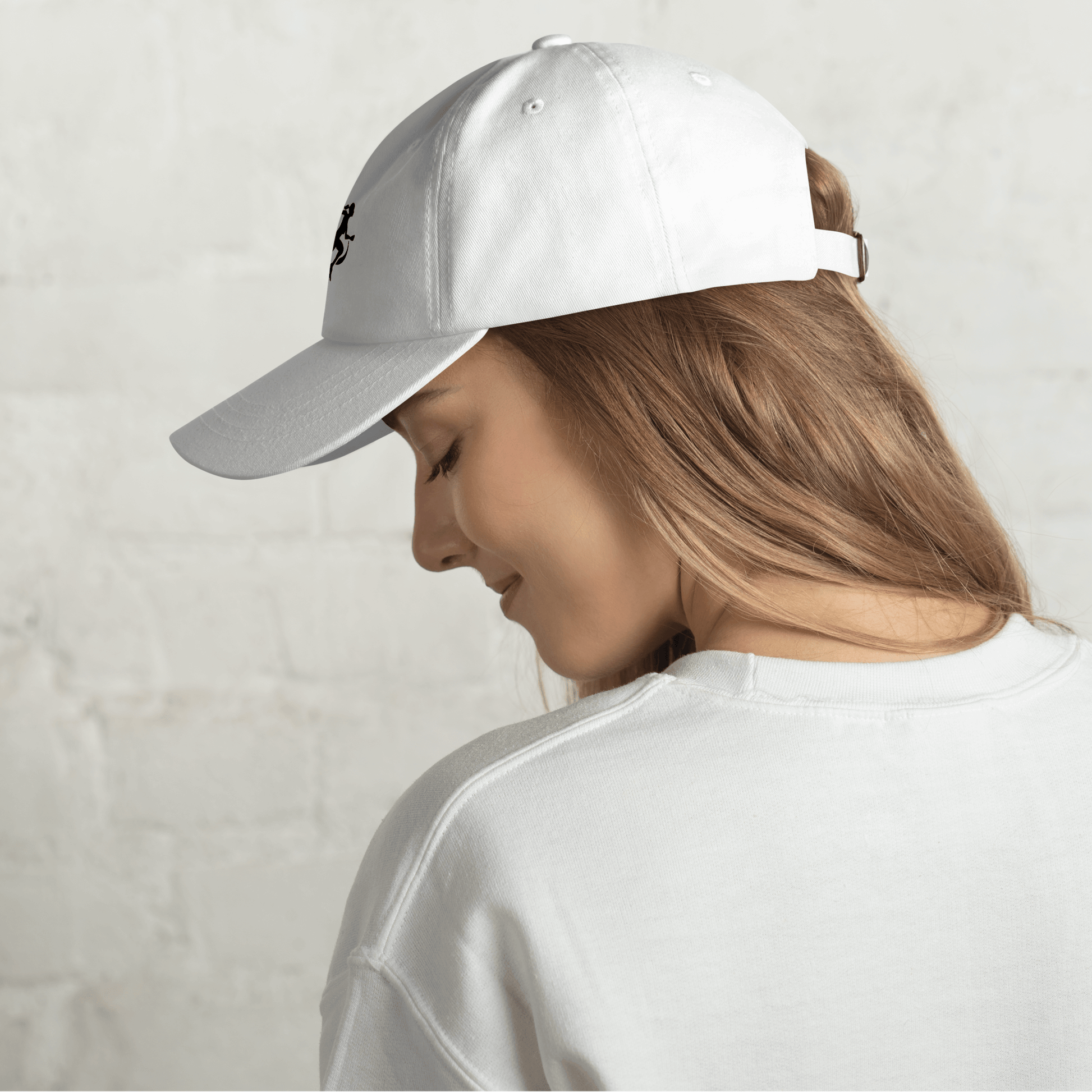 Woman wearing a white cap with a black logo on a white background