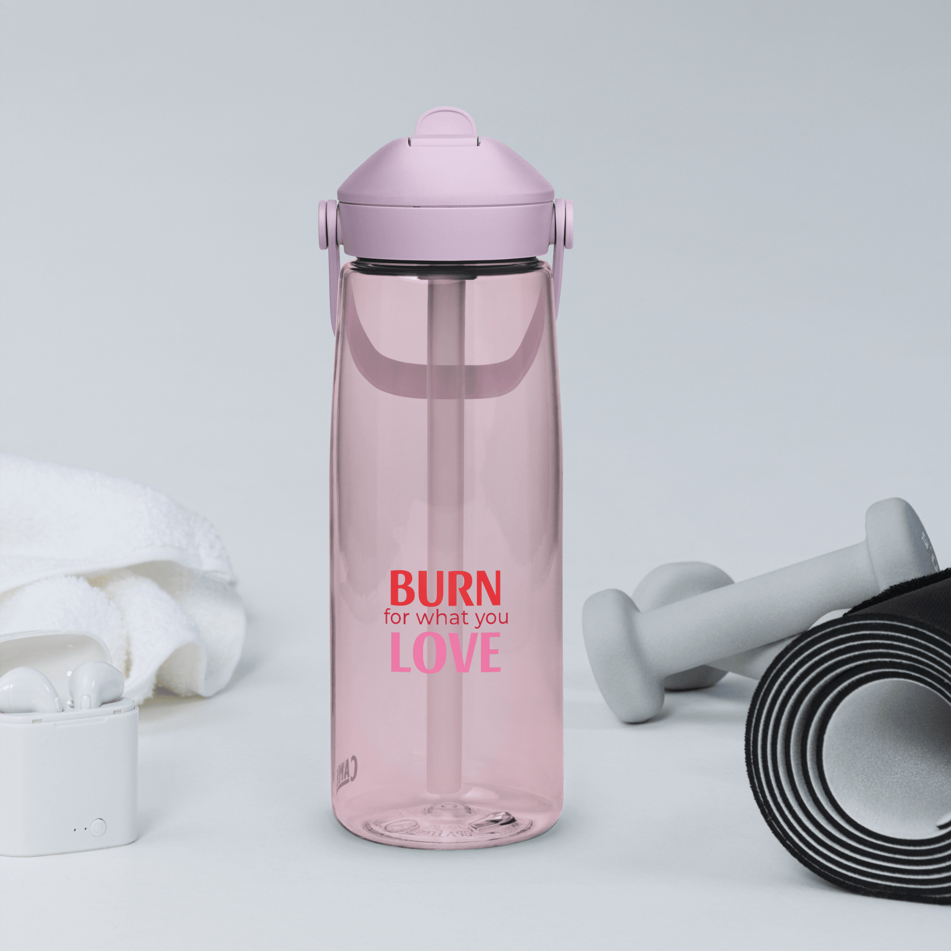 Pink water bottle with 'Burn for what you love' text, dumbbells, and resistance band on a light gray background