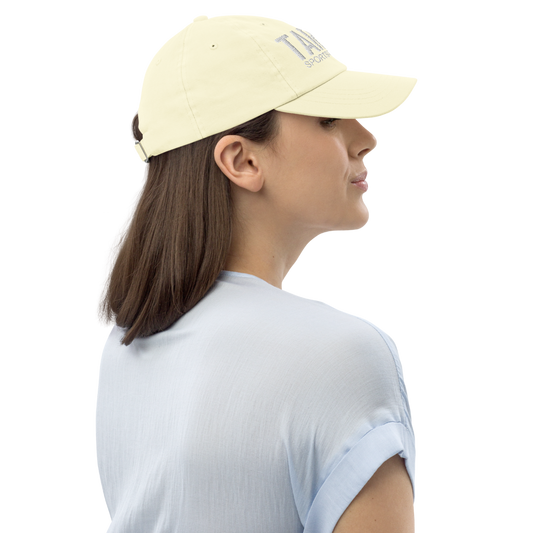 Woman wearing a light yellow cap with a logo on a white background