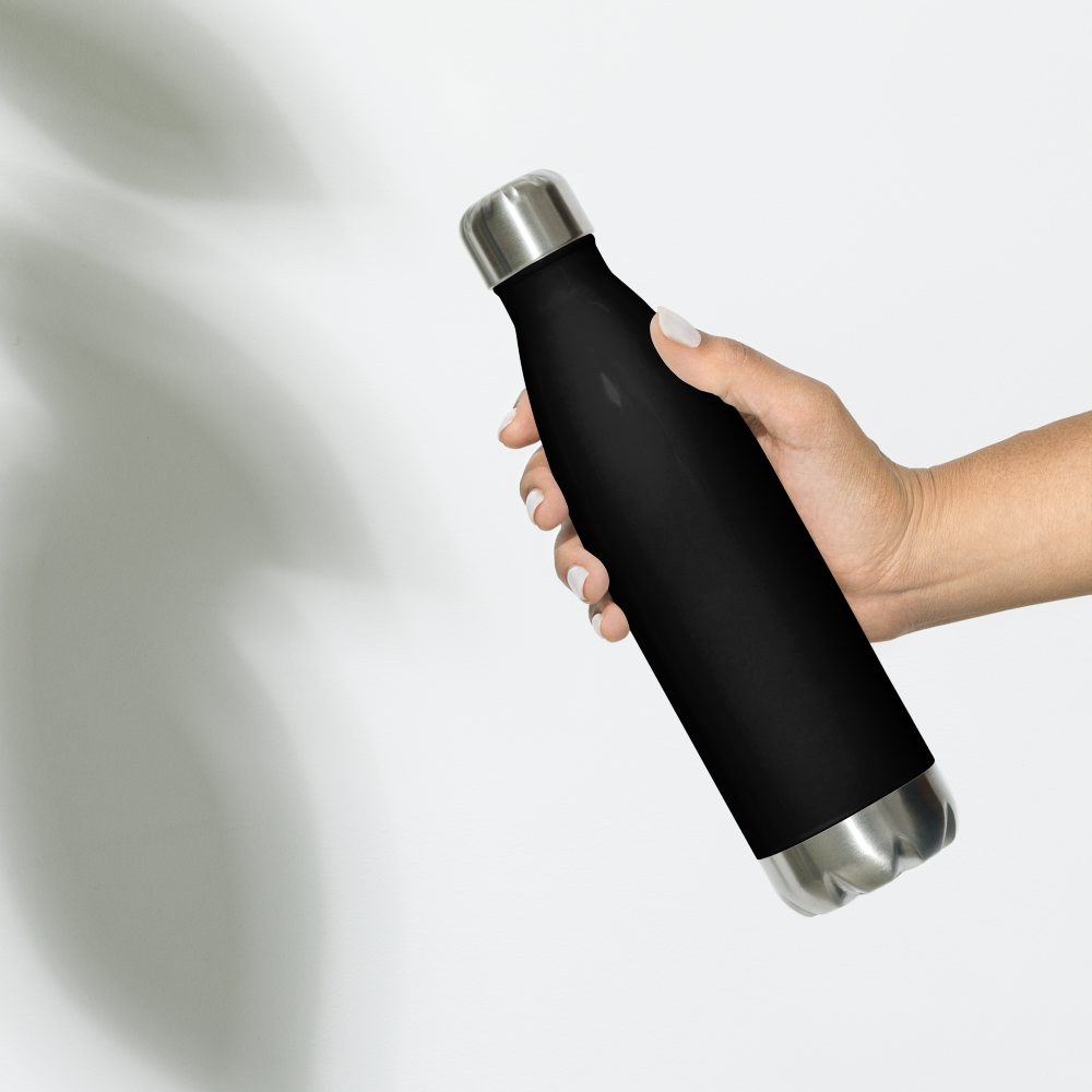 Person holding a black water bottle with a logo and text on a light gray background