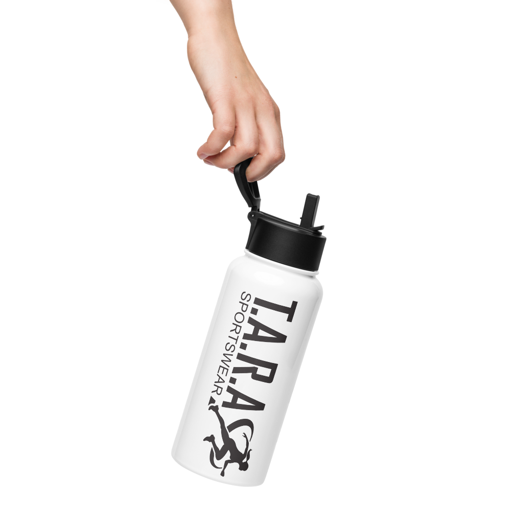 A white 32 oz (950 ml) water bottle with a black plastic lid and a wide-mouth foldable straw, lying on a rocky surface with a blurred background.
