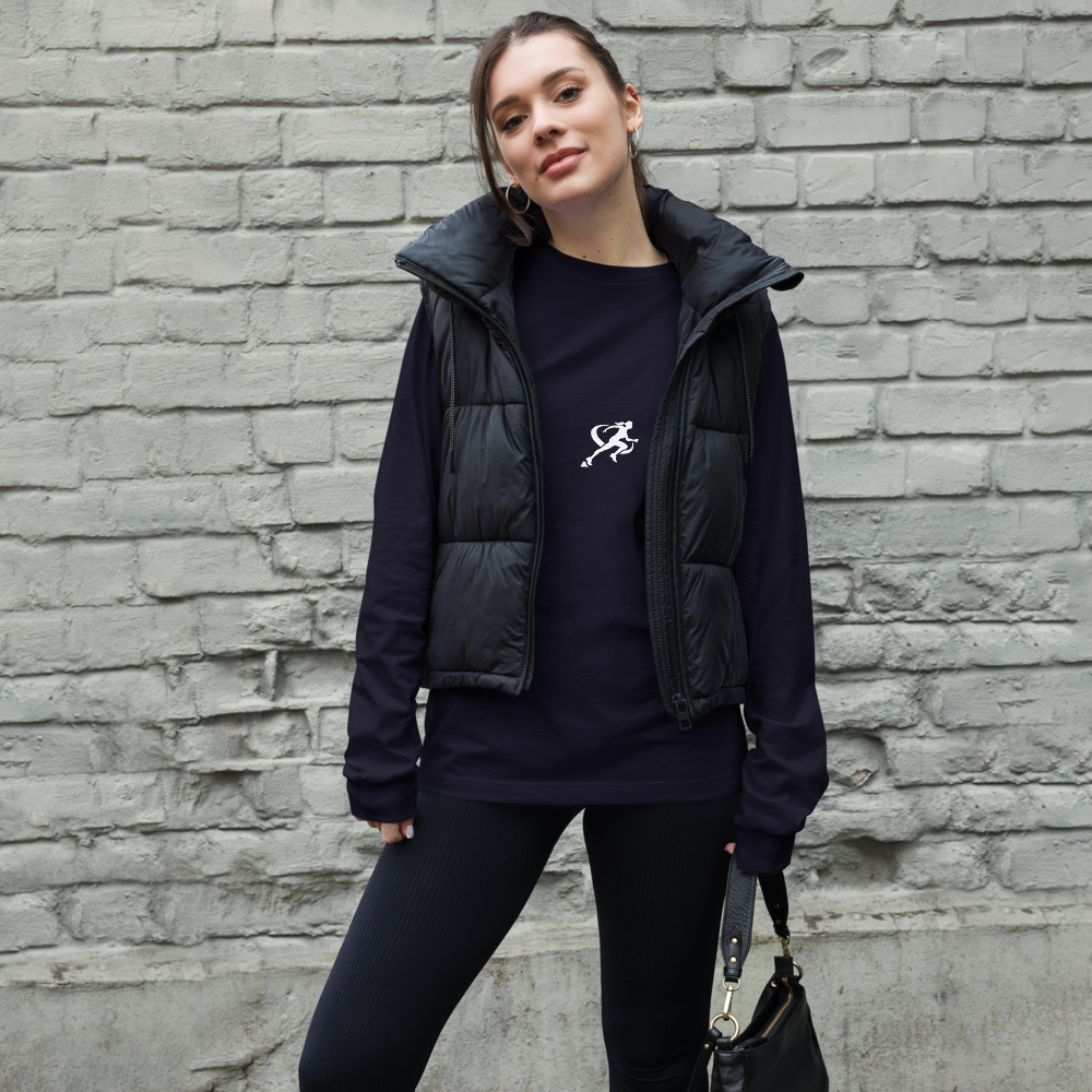 A woman wearing a black long-sleeved crew neck t-shirt with a small white logo on the chest.