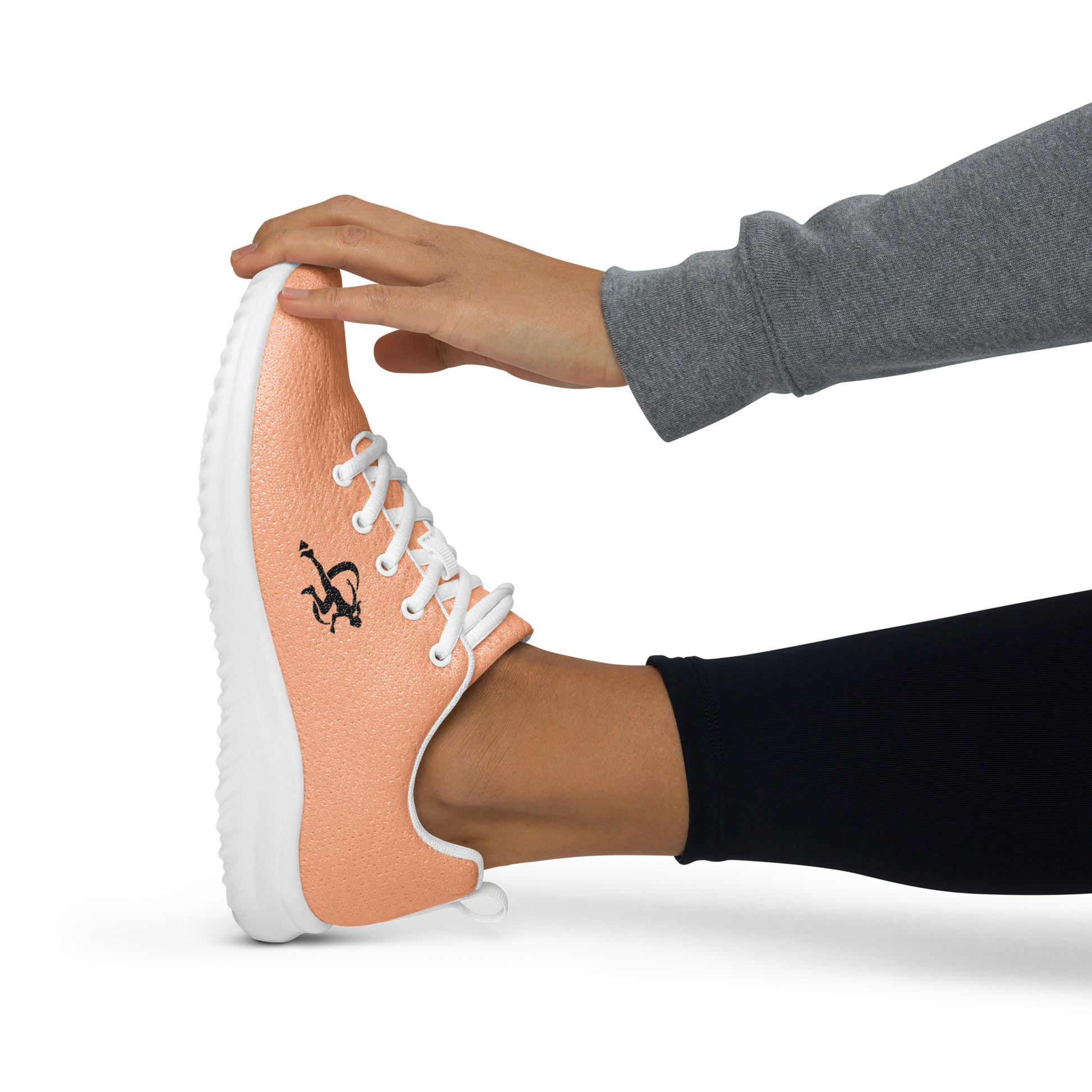 Coral running shoe with white laces on a reflective surface