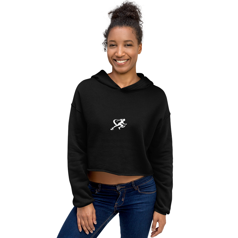 A woman wearing a black cropped hoodie with a graphic on the front standing against a neutral background.