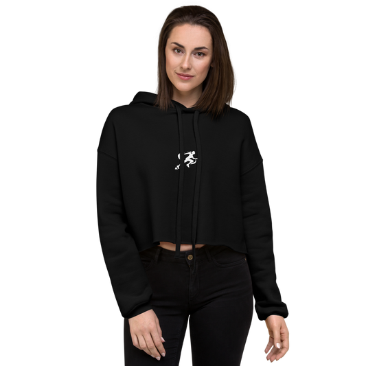 A woman wearing a black cropped hoodie with a graphic on the front standing against a neutral background.